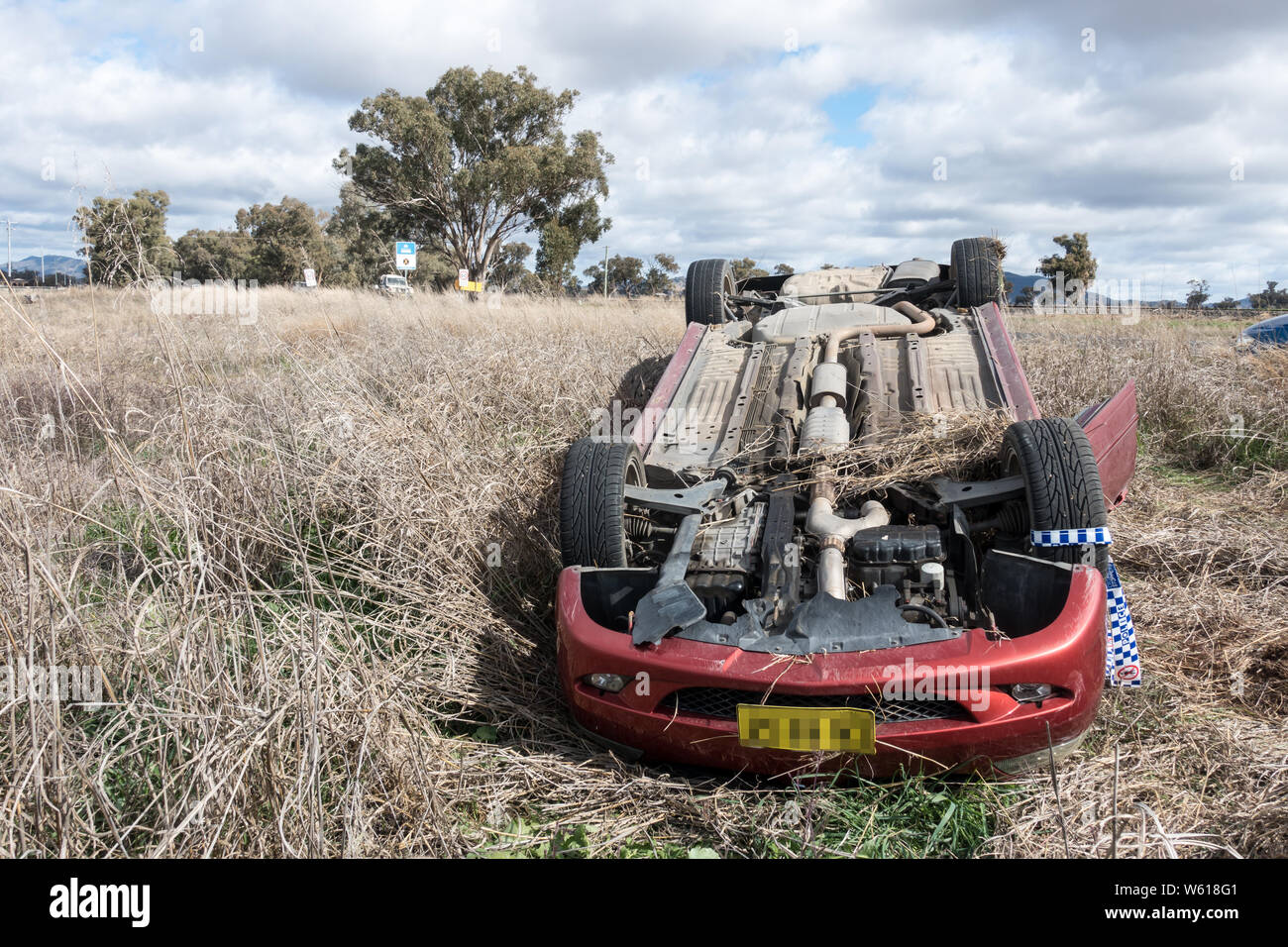 Mitsubishi sedan in roll over crash on country road Australia. Stock Photo