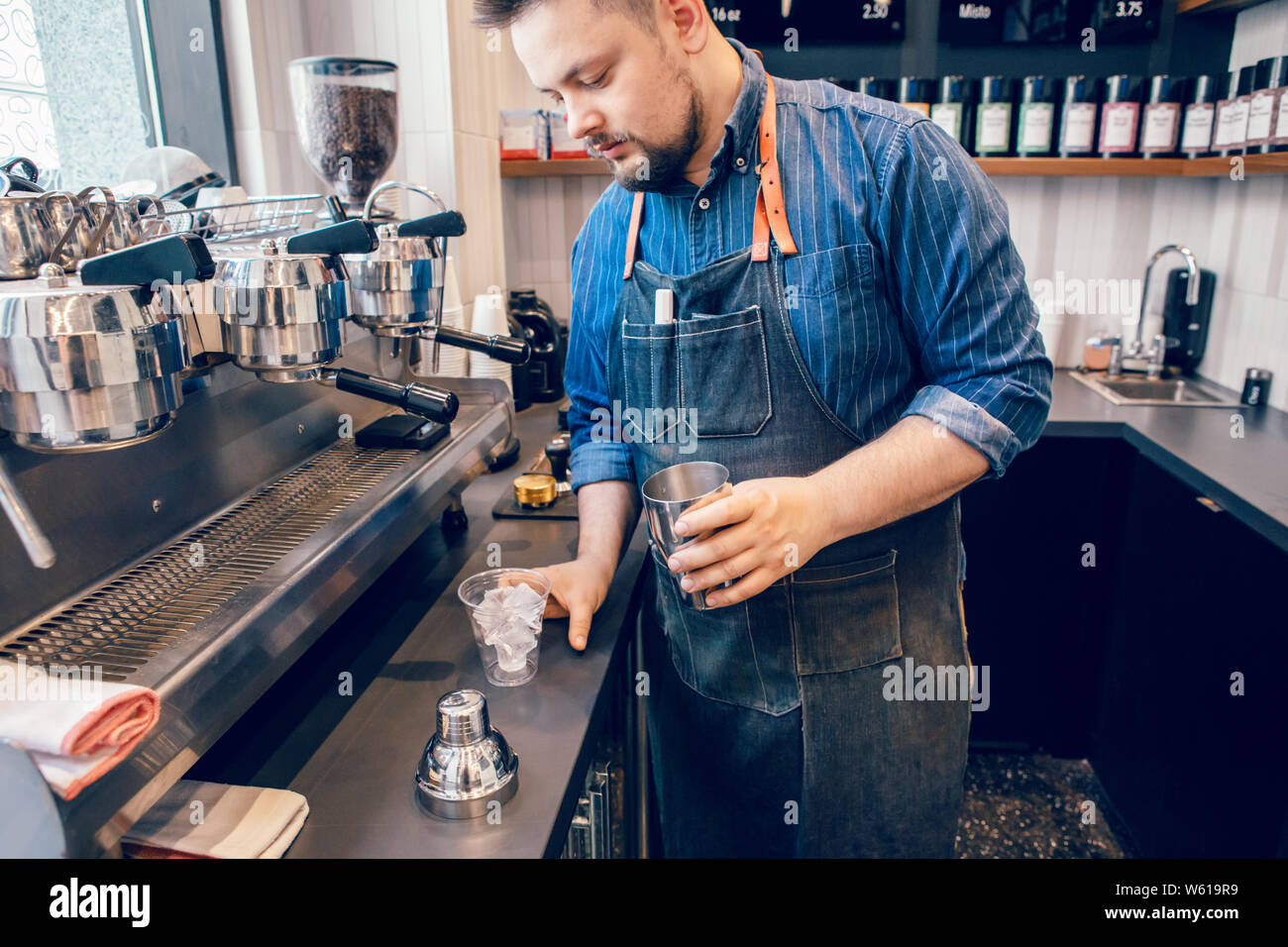 Caucasian handsome bearded man barista making cold iced coffee cappuccino  latte in shaker. Waiter server pouring drink in plastic transparent cup.  Sma Stock Photo - Alamy