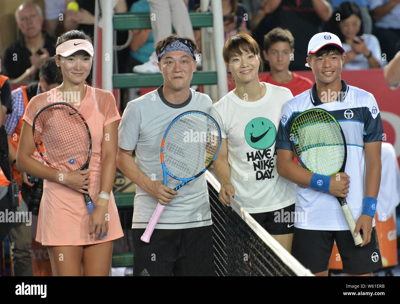 Retired Chinese tennis star Li Na, second right, and Hong Kong singer Eason Chan, second left, are pictured at a celebrity exhibition match during the Stock Photo