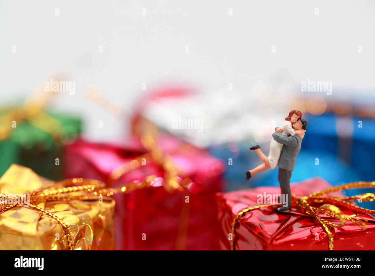 Miniature people: a couple celebrating on christmas gift boxes Stock Photo