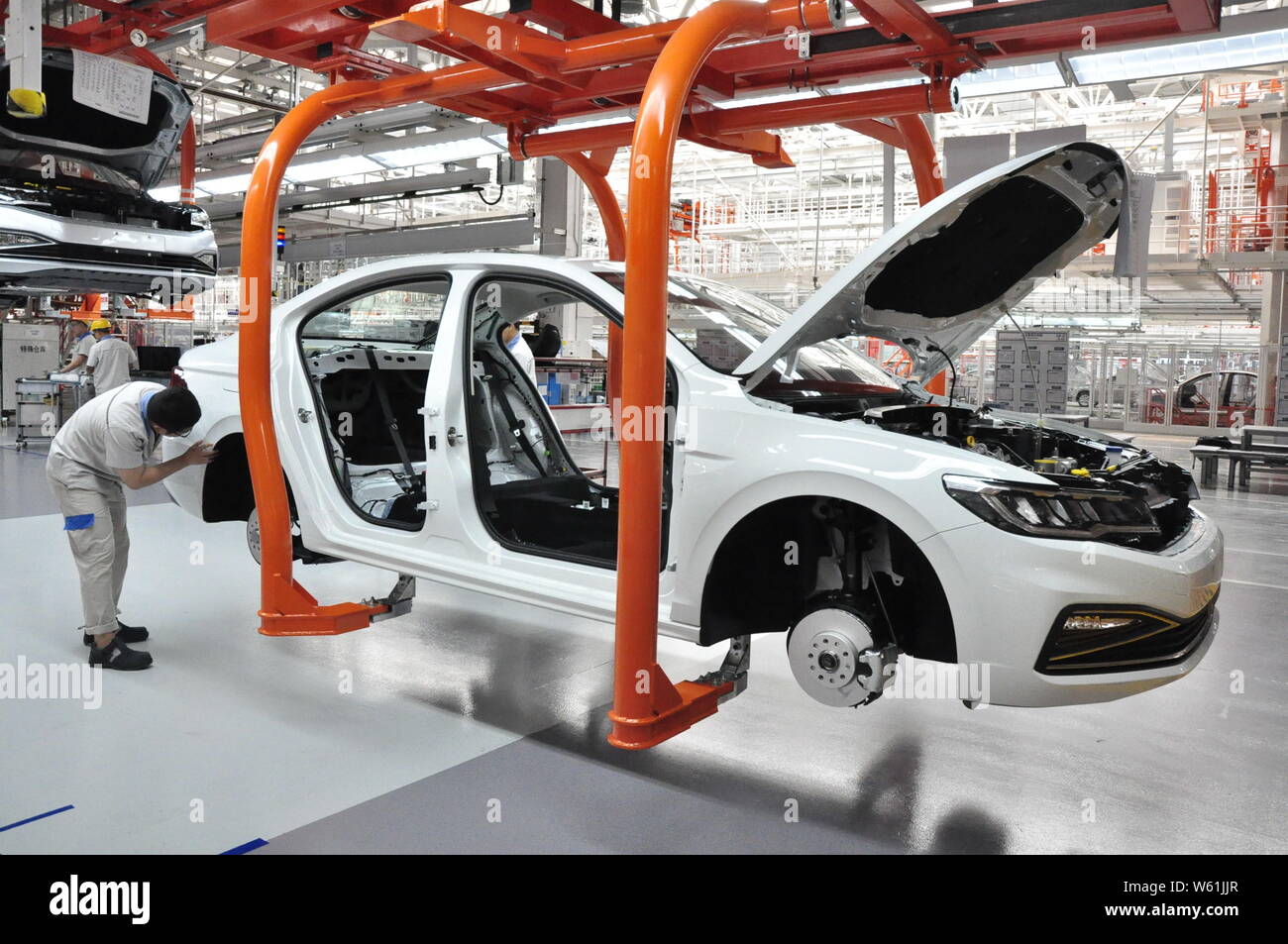 --FILE--A Chinese worker manufactures a car at a plant of FAW Volkswagen in Qingdao city, east China's Shandong province, 16 August 2018.   China's in Stock Photo