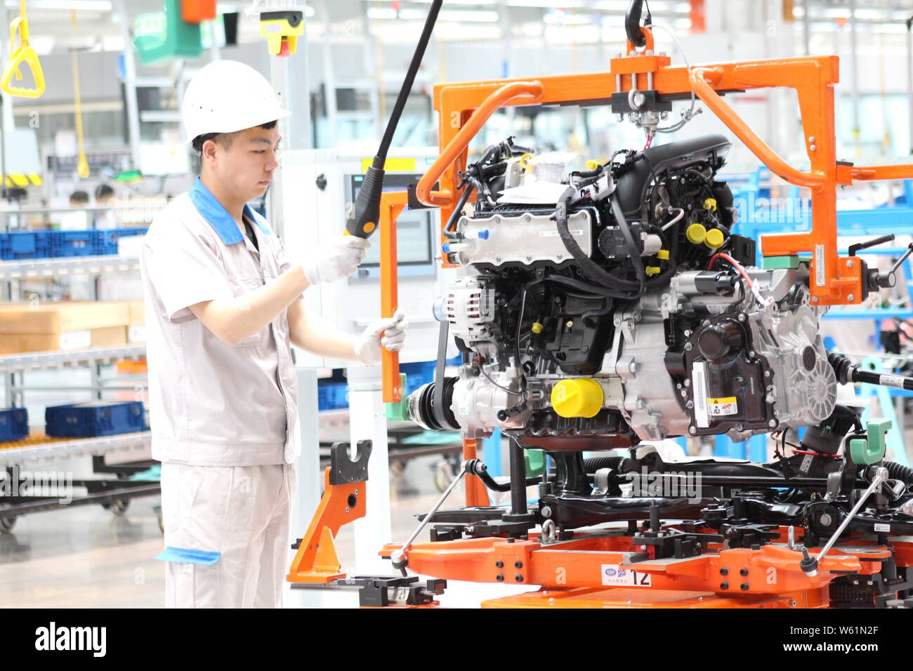 A Chinese worker manufactures cars at a plant of FAW Volkswagen in Qingdao city, east China's Shandong province, 16 August 2018.   China's investment Stock Photo