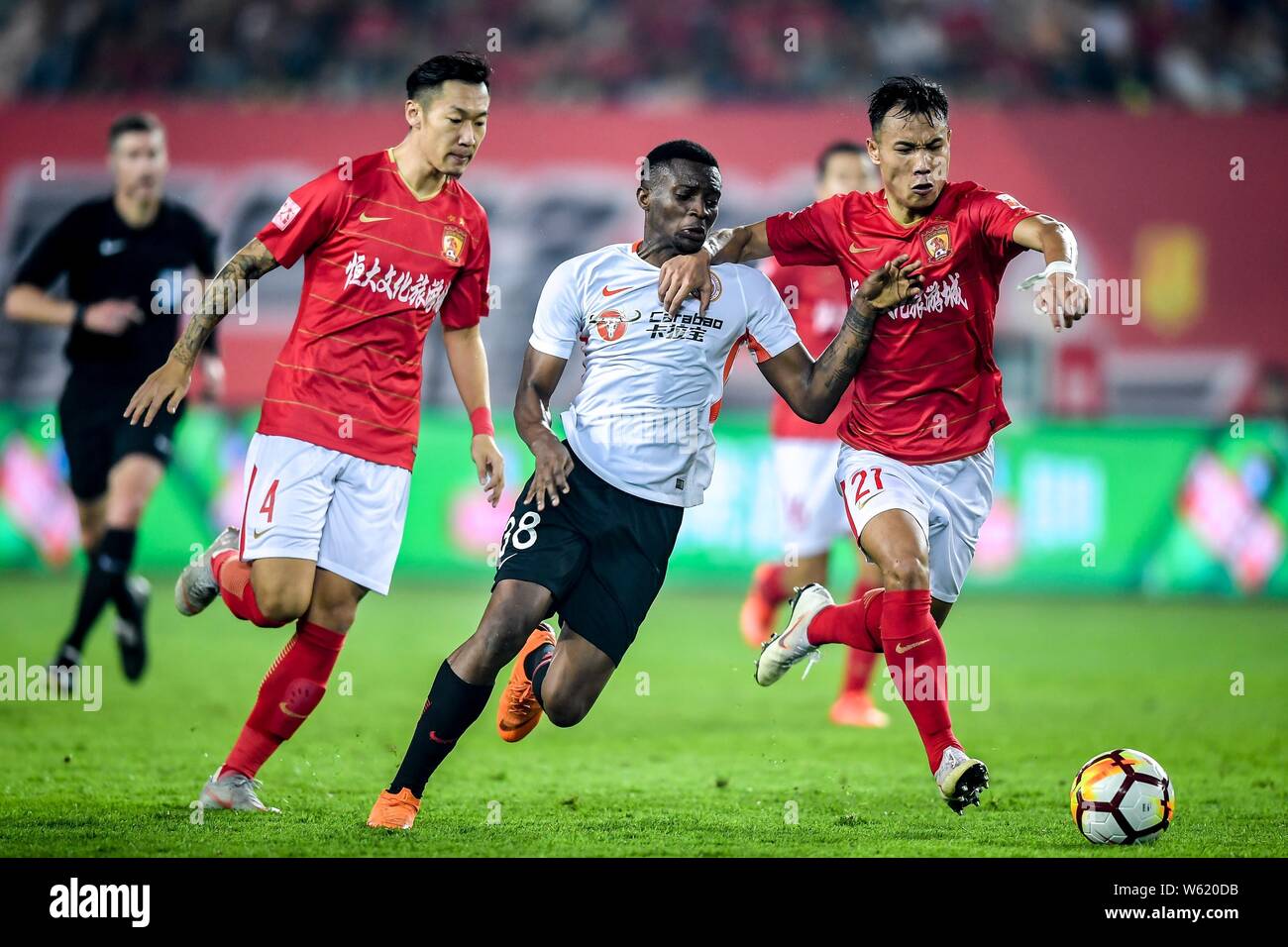 Cameroonian football player Benjamin Moukandjo, center, of Beijing Renhe passes the ball against players of Guangzhou Evergrande Taobao in their 26th Stock Photo