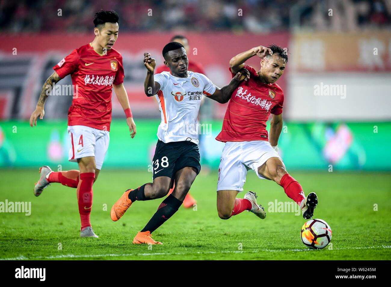 Cameroonian football player Benjamin Moukandjo, center, of Beijing Renhe passes the ball against players of Guangzhou Evergrande Taobao in their 26th Stock Photo