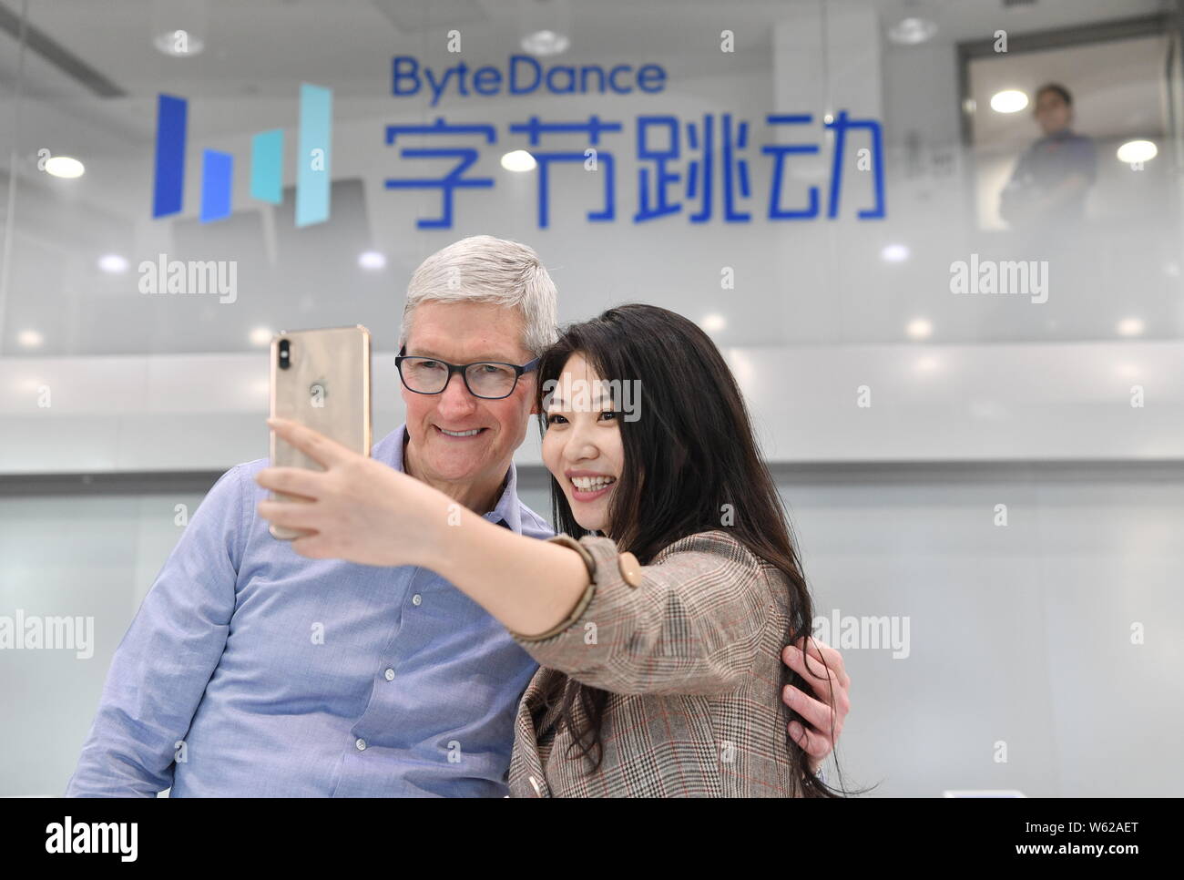 Apple Inc. CEO Tim Cook, left, poses with a ByteDance employee for a selfie during his visit to the headquaters of ByteDance in Beijing, China, 11 Oct Stock Photo