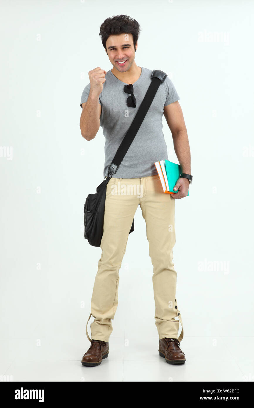 College boy holding books and punching the air Stock Photo Alamy