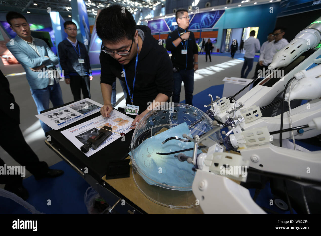 Members of the press look at a porotic laparoscopic surgery robot