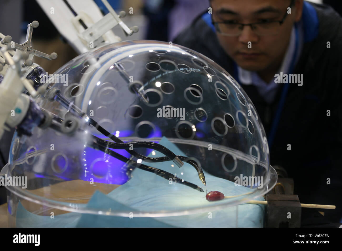 Members of the press look at a porotic laparoscopic surgery robot
