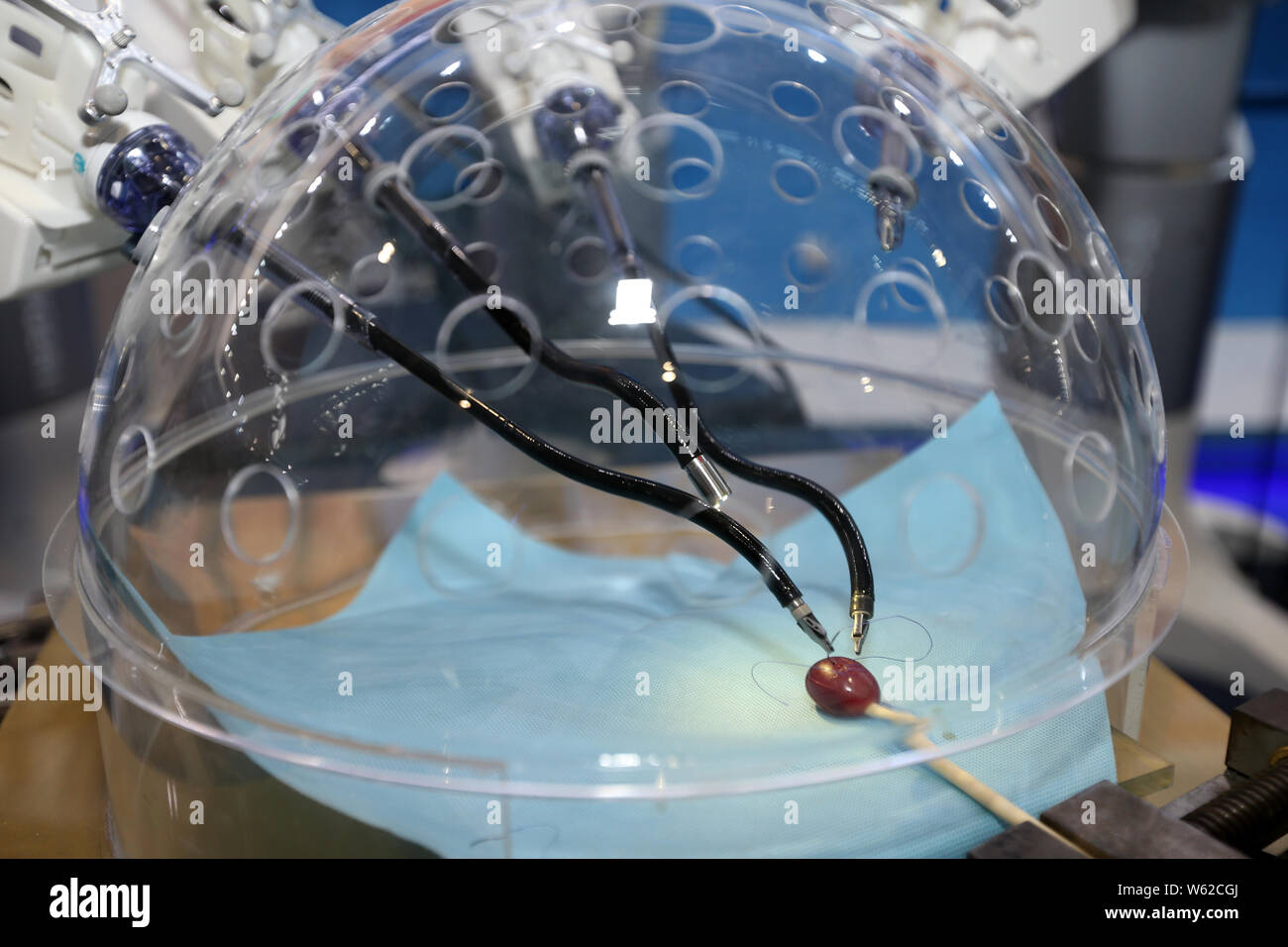 Members of the press look at a porotic laparoscopic surgery robot