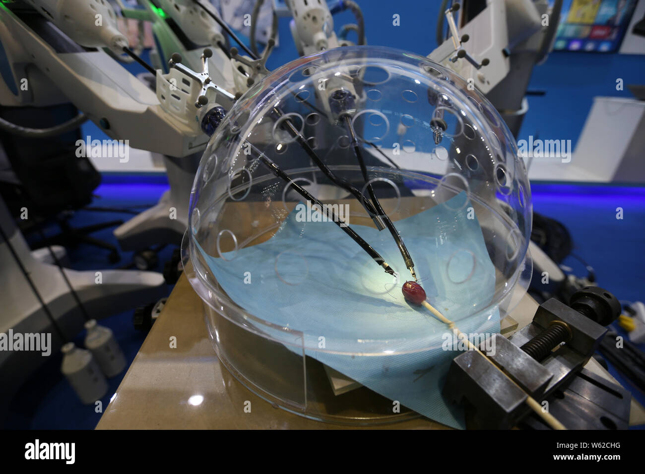 Members of the press look at a porotic laparoscopic surgery robot