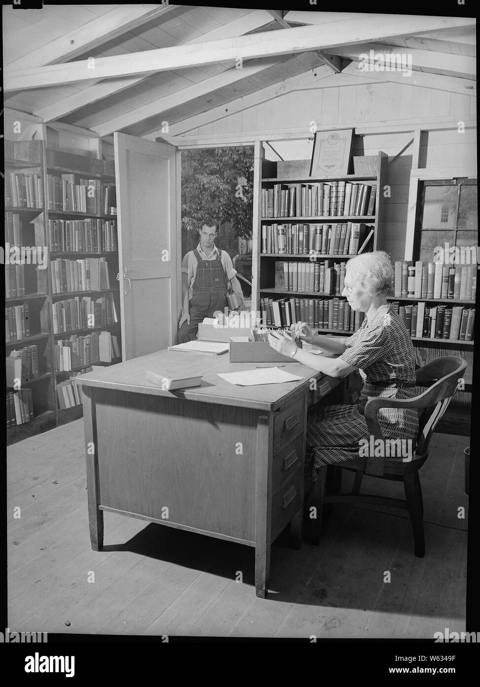Charlestown, Indiana. Education, Library Services.; Scope and content:  Charlestown, Indiana. Education, Library Services. The Public Library in Charlestown, Indiana was constructed out of work shanties by Works Progress Administration (WPA) workers in the early days of the Charlestown boom and is staffed by Works Progress Administration librarians. It has between three thousand and four thousand books and there is a demand for more technical texts on chemistry, steam fitting, mechanical drawing, mathematics and carpentry. The library is well partonized by the newcomers and townsfolk alike; th Stock Photo