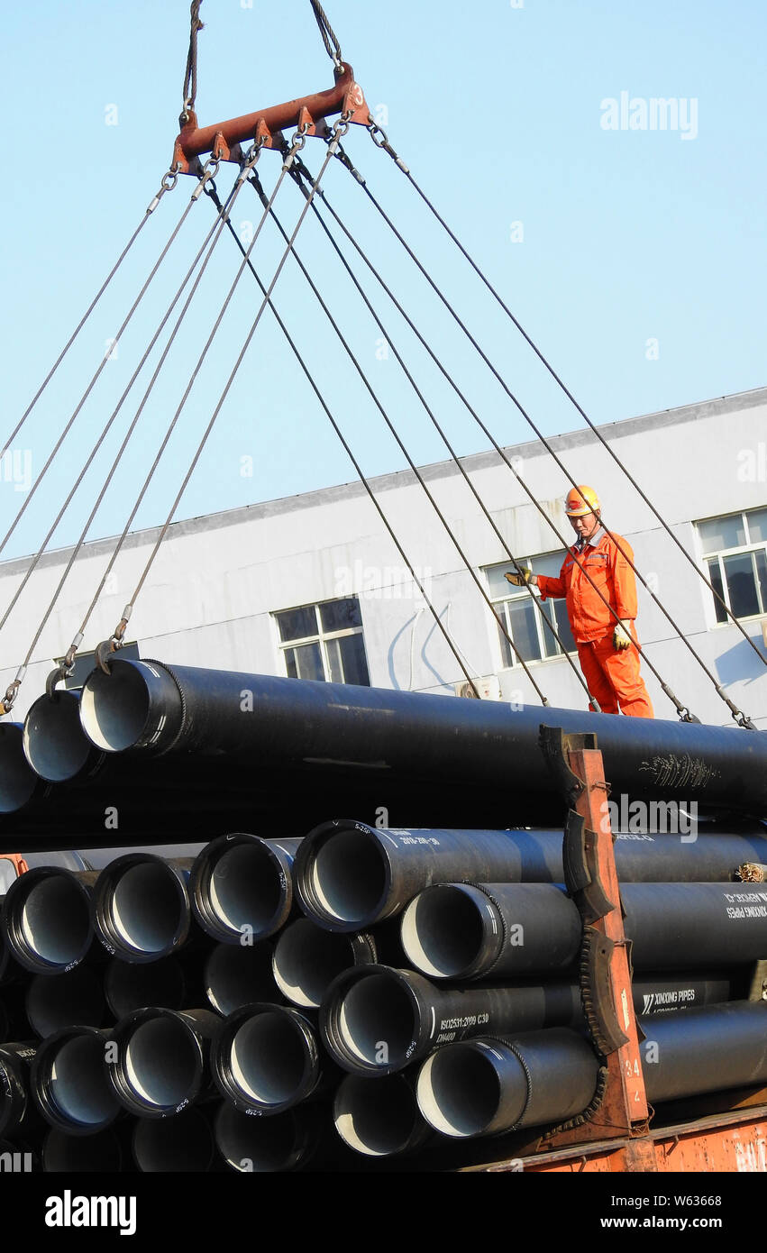 chinese-workers-directs-a-crane-to-load-steel-tubes-to-be-exported-onto