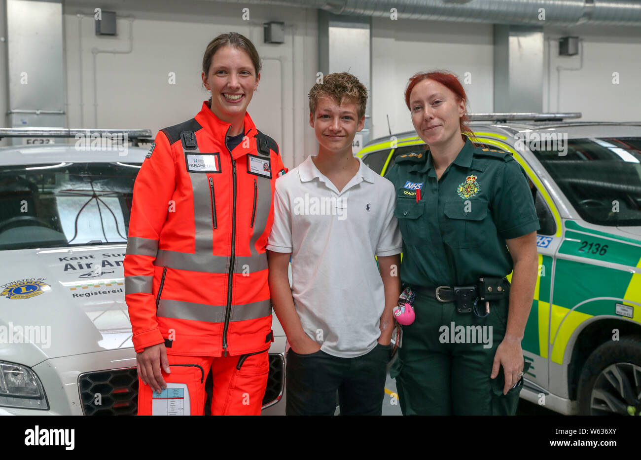 Joe Pelham, 14, meets the Paramedic Sam Taylor (left) from the Air Ambulance Kent Sussex Surrey, and South East Coast Ambulance operation team leader Tracey Willmont-Coles (right), who saved his life at Air Ambulance's Redhill base in Surrey. Joe was treated by the team after he'd been hit by a car whilst cycling. Stock Photo