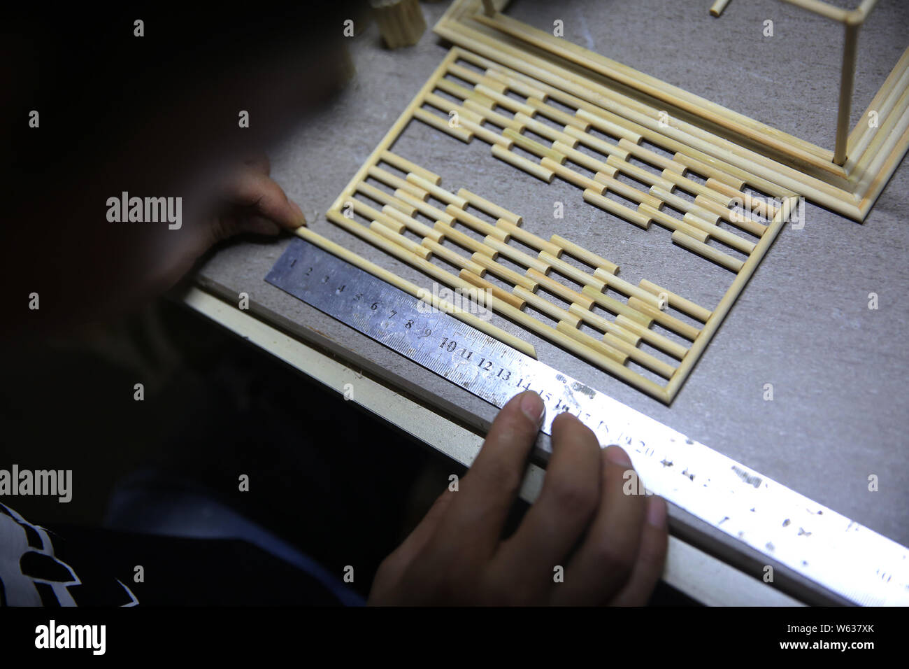 Chinese restaurant owner Xu Ruibin uses a steel ruler to measure the ...