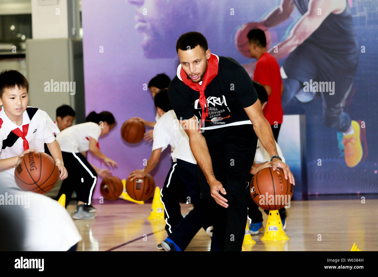 NBA star Stephen Curry, center, of Golden State Warriors plays basketball during his visit to Primary School Attached to Huazhong University of Scienc Stock Photo