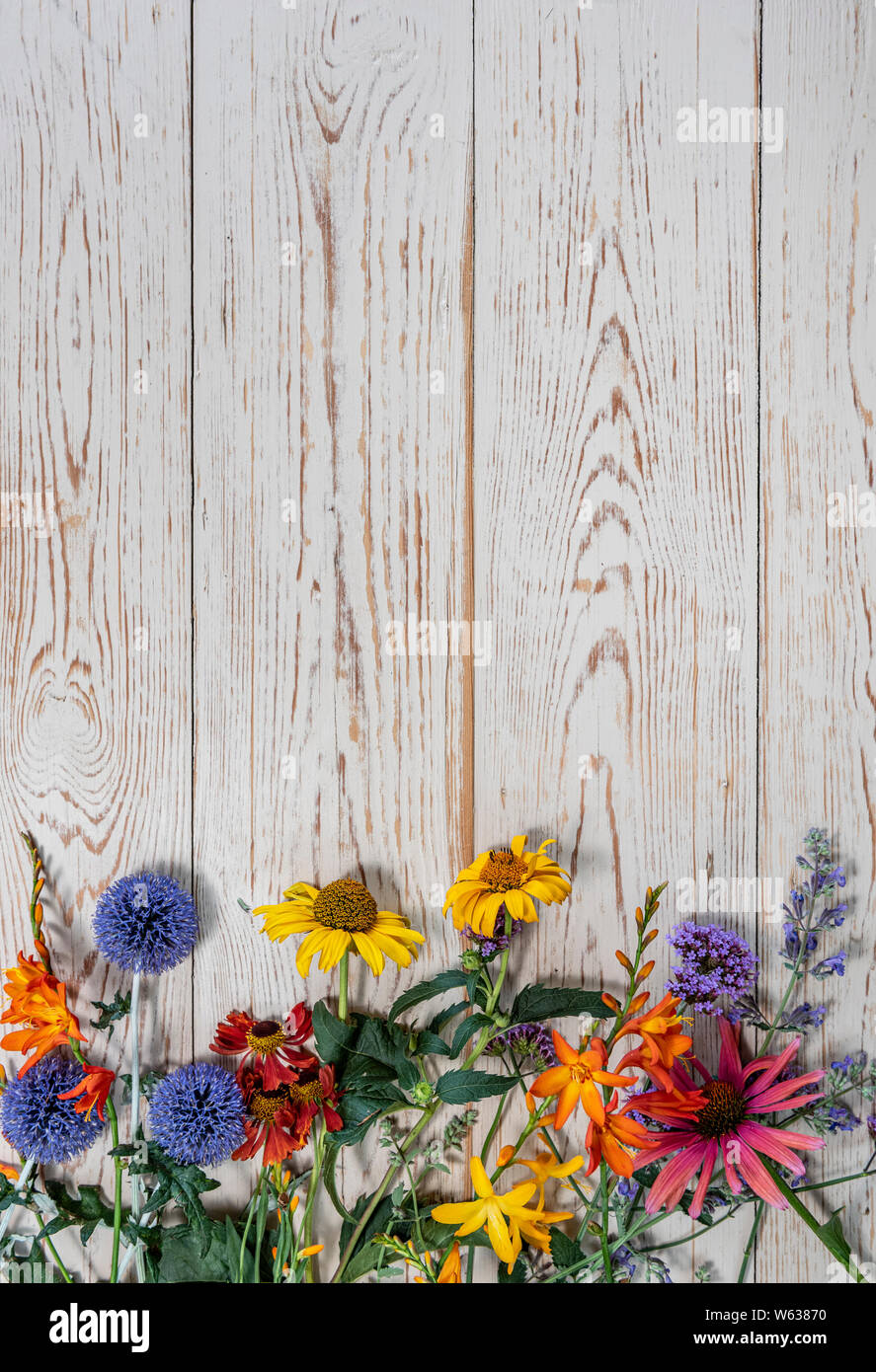 Summer flowers laid on a wooden table, with copy space. Stock Photo