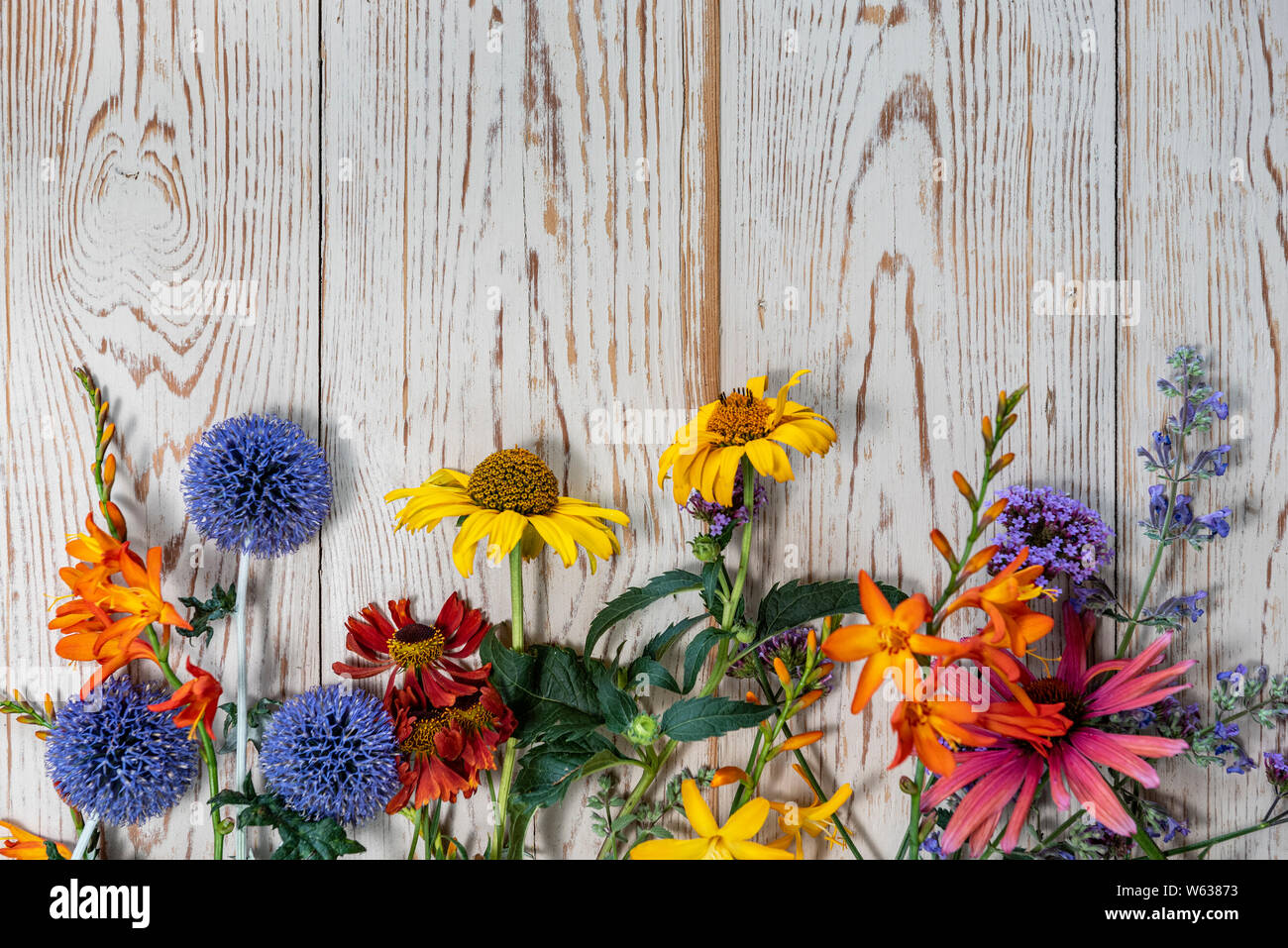 Summer flowers laid on a wooden table, with copy space. Stock Photo