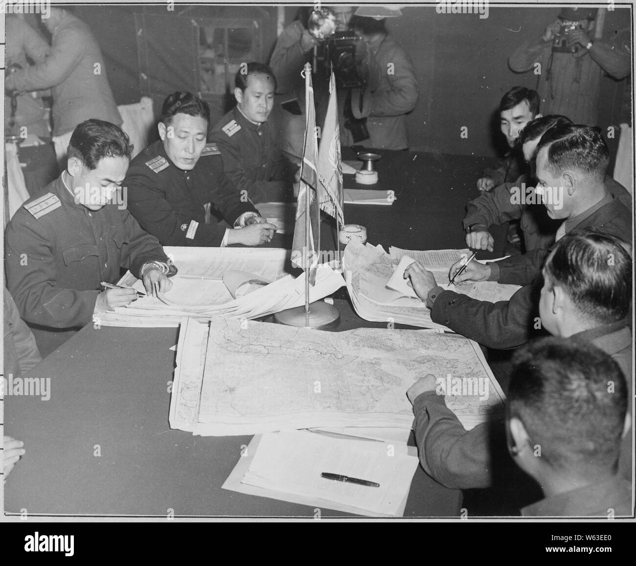Colonel James Murray, Jr., USMC, and Colonel Chang Chun San, of the North Korean Communist Army, initial maps showing the north and south boundaries of the demarcation zone, during the Panmunjom cease fire talks.; General notes:  Use War and Conflict Number 1516 when ordering a reproduction or requesting information about this image. Stock Photo