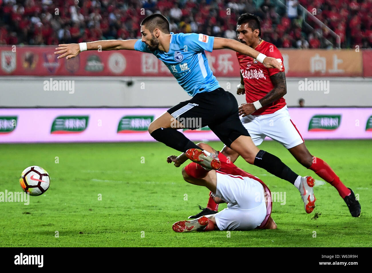 Belgian professional football player Yannick Ferreira Carrasco, front, of Dalian Yifang dribbles against Guangzhou Evergrande Taobao in their 24th rou Stock Photo