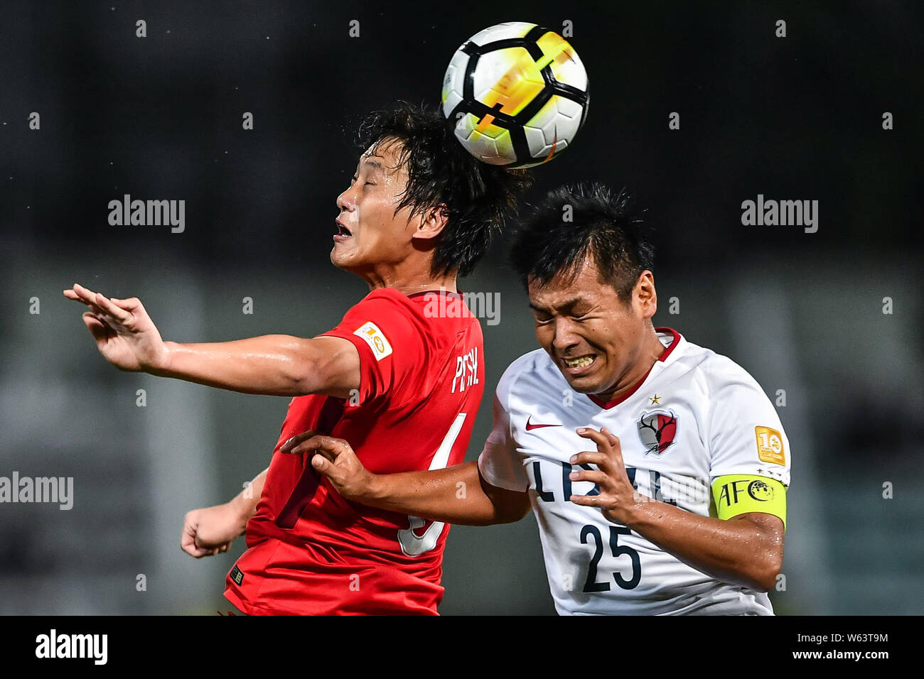Pei Shuai, left, of China's Tianjin Quanjian heads the ball against Yasushi Endo of Japan's Kashima Antlers in their quarterfinal 2nd leg match during Stock Photo