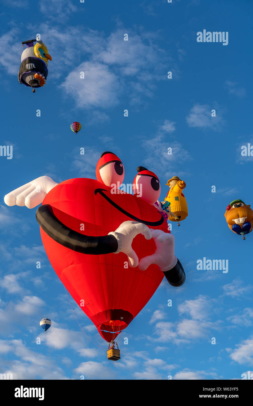 Human like heart shaped hot air balloon hovering in the blue sky. Stock Photo