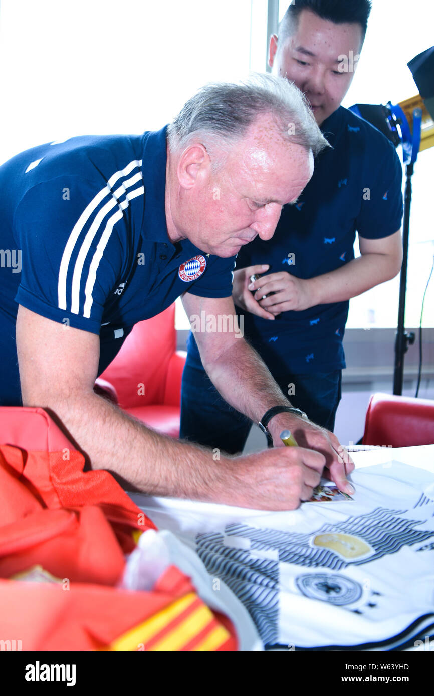German football coach and former football defender Andreas Brehme signs autographs for fans during his China tour at the FC Bayern office in Shanghai, Stock Photo