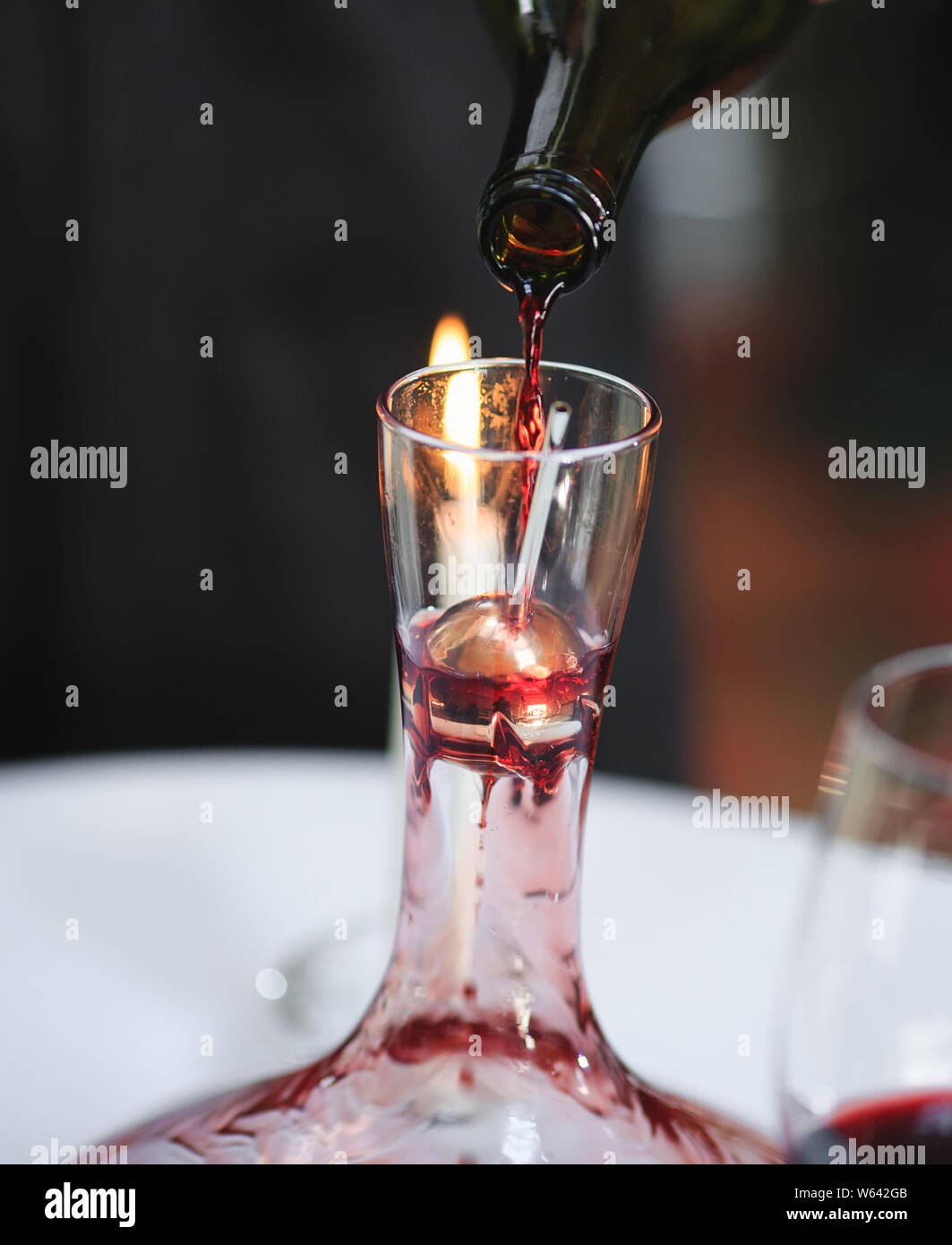 A sommelier pouring red wine into decanter Stock Photo Alamy