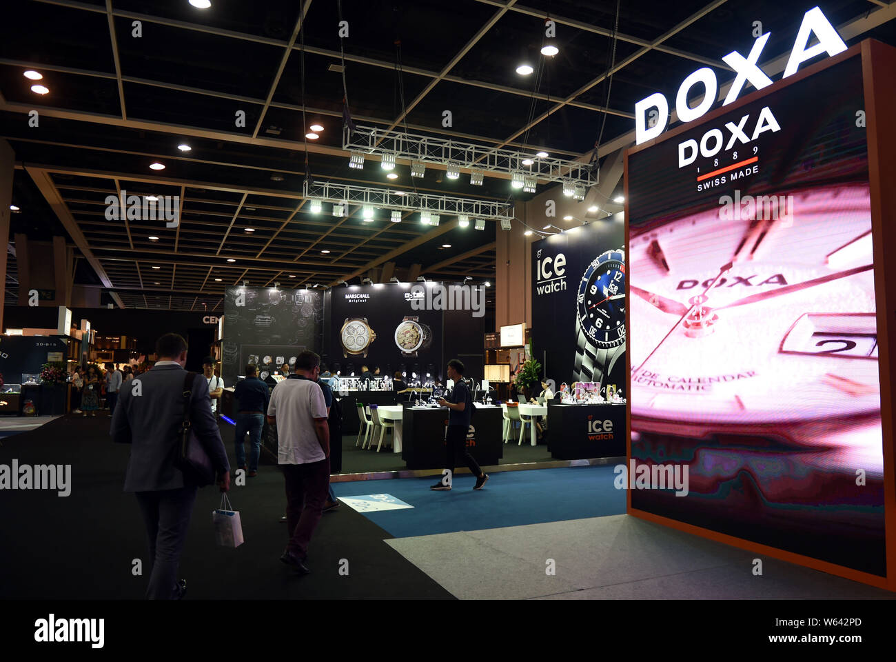 Visitors walk past stands of watchmakers during the Hong Kong Watch