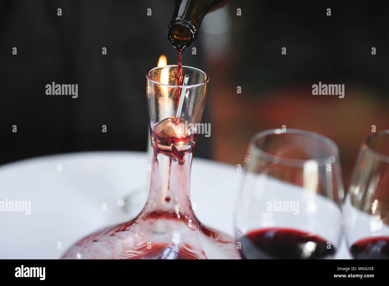 A sommelier pouring red wine into decanter Stock Photo Alamy
