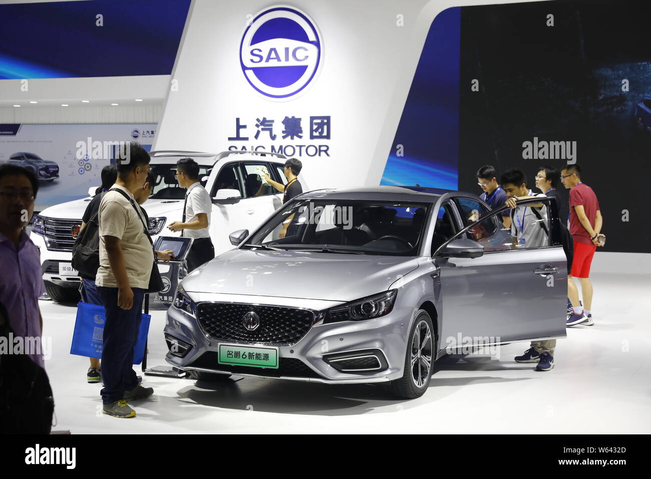 Chinese visitors view MG 6 and Roewe RX8 hybrid cars of SAIC Motor on display during the 20th China International Industry Fair (CIIF 2018) in Shangha Stock Photo