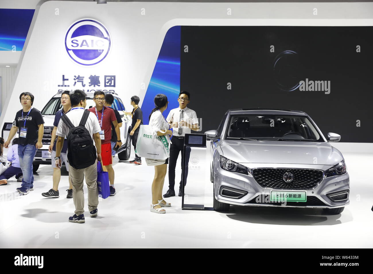 Chinese visitors view MG 6 and Roewe RX8 hybrid cars of SAIC Motor on display during the 20th China International Industry Fair (CIIF 2018) in Shangha Stock Photo