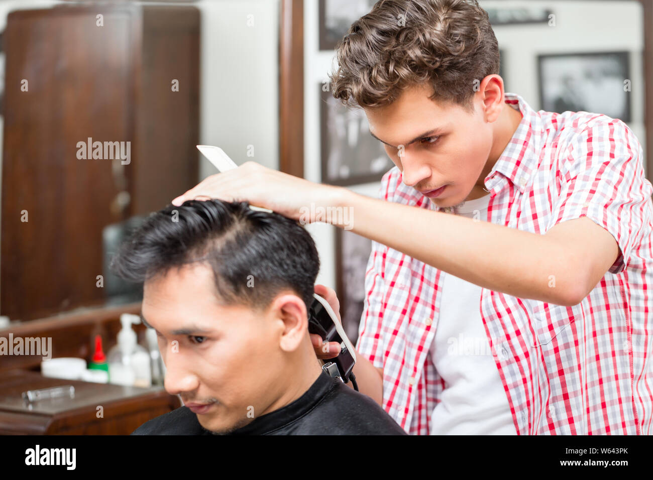 Hairdresser cutting hair with trimmer Stock Photo Alamy