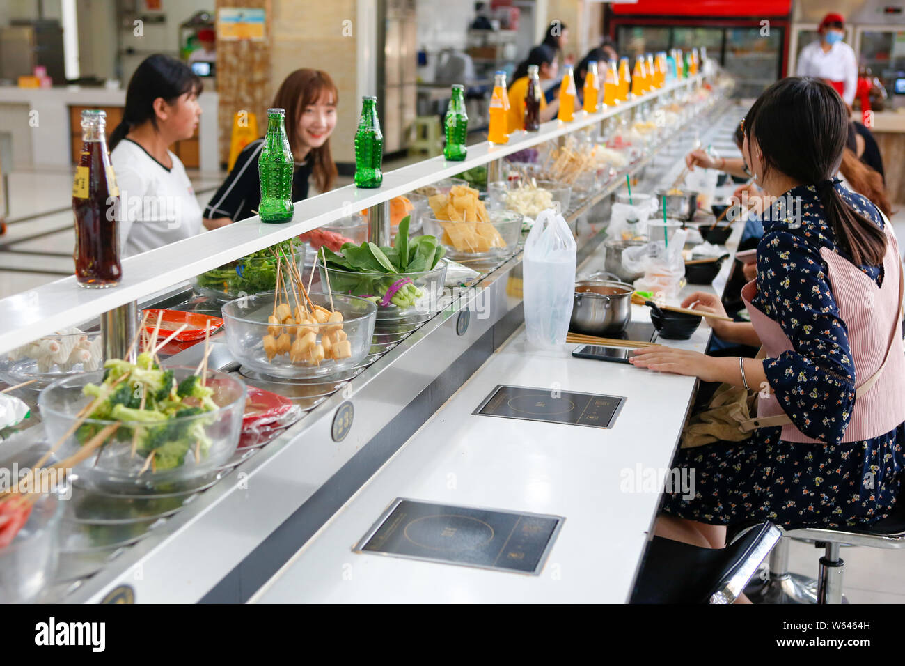 Students eat conveyor belt hotpot, literally "rotation hot pot," at a