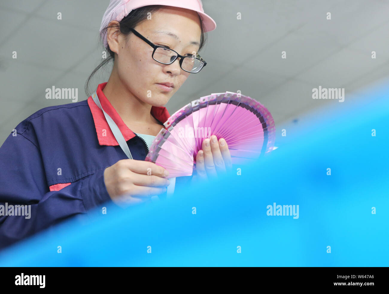 --FILE--A Chinese worker checks chips for electronic products at a ...