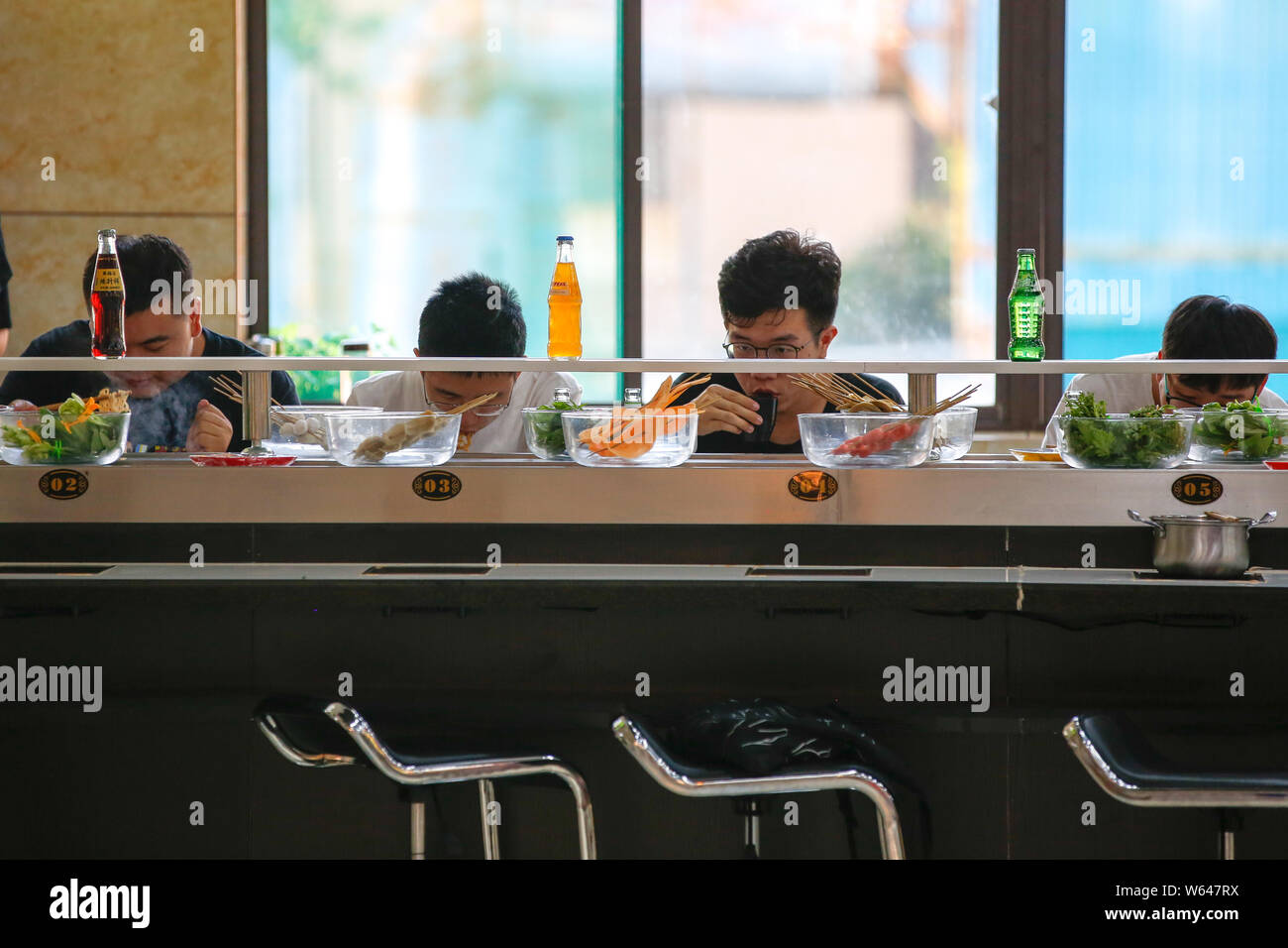 Students eat conveyor belt hotpot, literally "rotation hot pot," at a