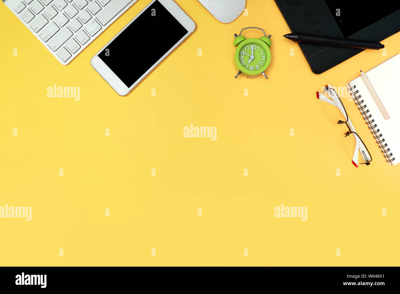 graphic designer desk top view with computer, smart phone, glasses