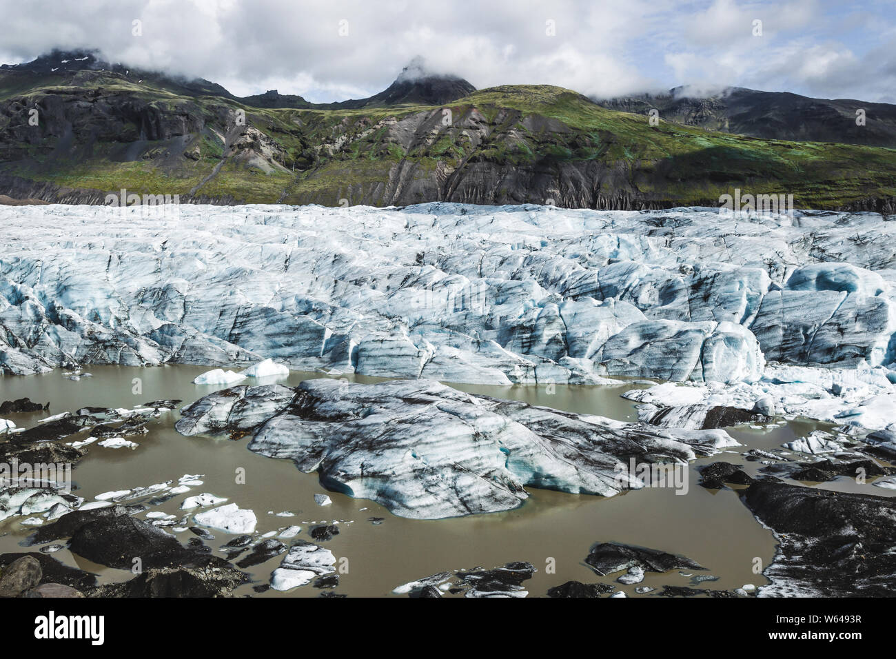Skaftafell glacier landscape in Svinafell, Iceland. Background of green  mountains, ice and snow. Melting glaciers, global warming Stock Photo -  Alamy