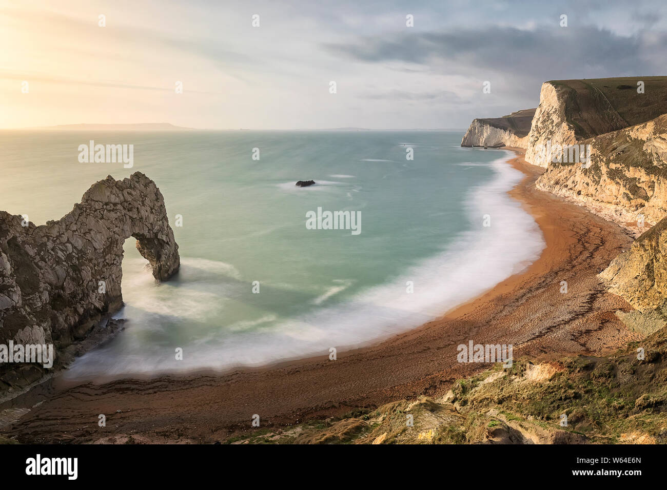View on Durdle Door at sunny day. Natural limestone arch on Jurassic coastline of Dorset. West Lulworth. North Sea. UK. Long exposure. Stock Photo