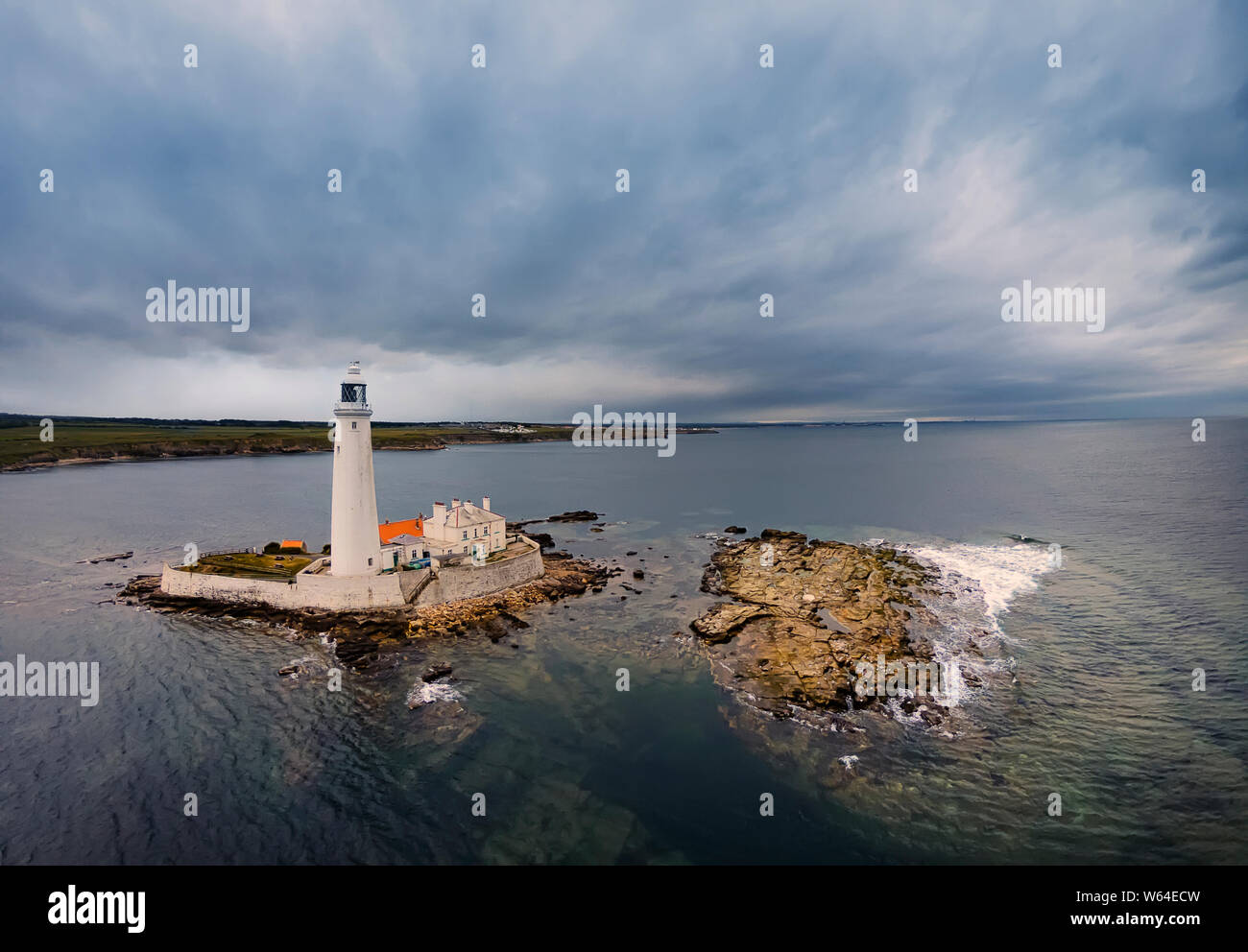 Amazing clouds above St. Mary's Lighthouse. Lighthouse and rocks during