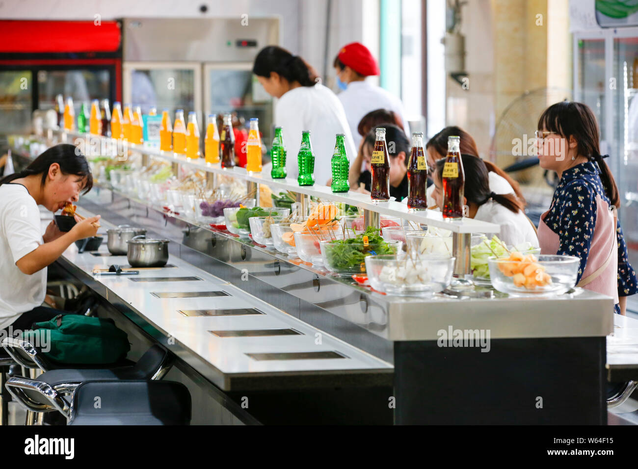 Students eat conveyor belt hotpot, literally "rotation hot pot," at a