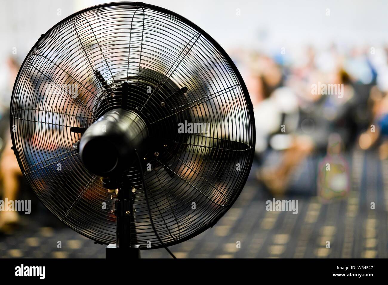Ventilator in details, fan blower in action during hot conference day,  people in background Stock Photo - Alamy