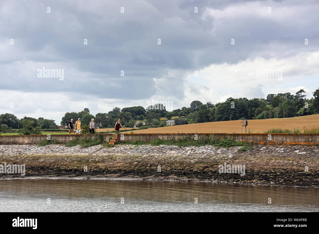 Taking a stroll along the sea wall by the River Exe in south Devon Stock Photo