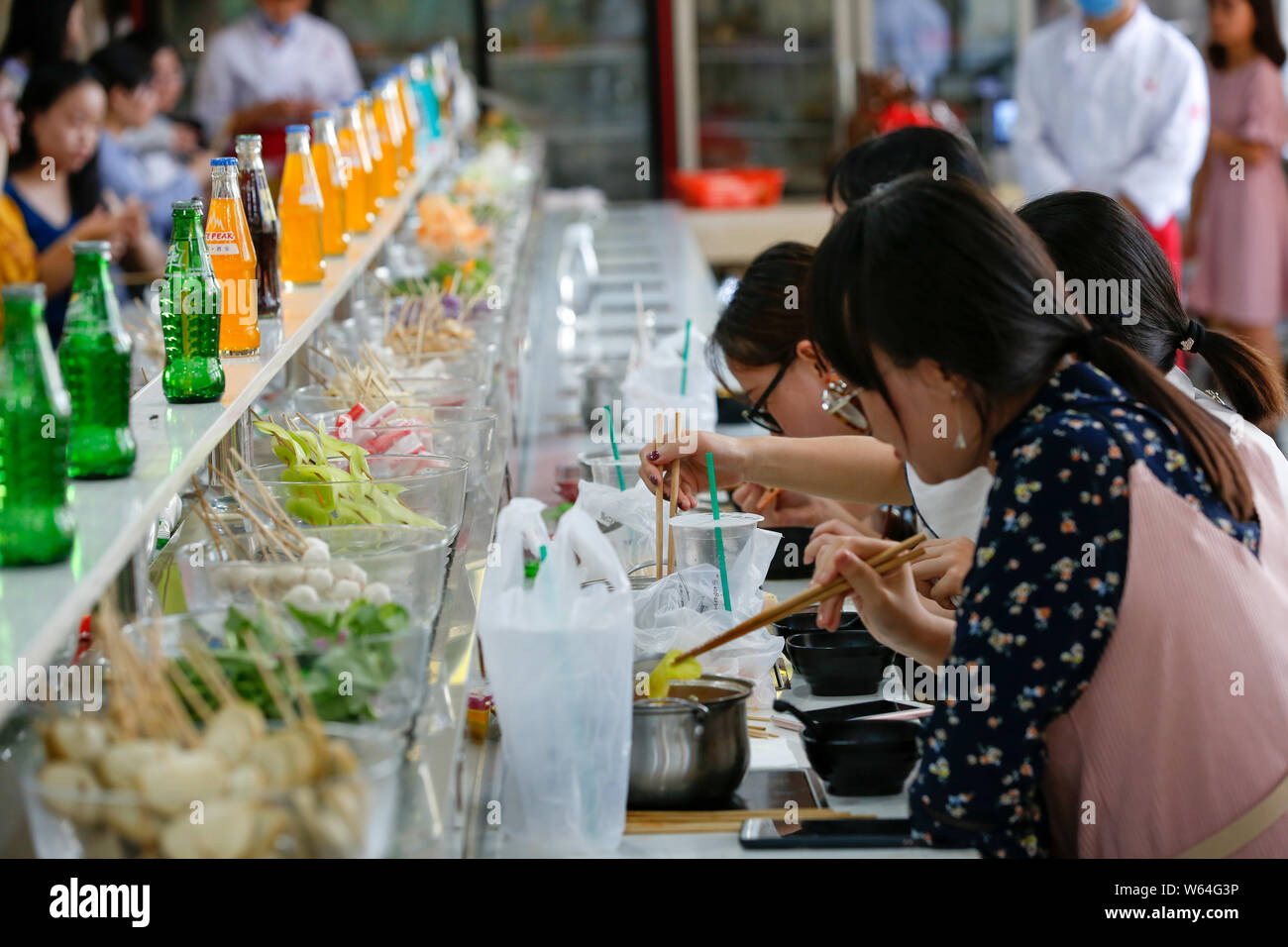 Students eat conveyor belt hotpot, literally "rotation hot pot," at a