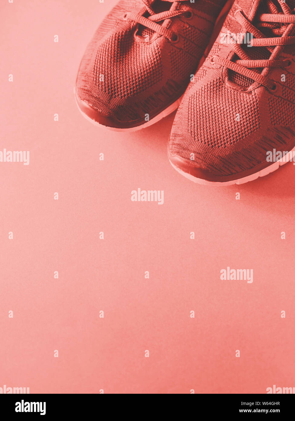 Sports trainers on empty background. Coral pink tone Stock Photo - Alamy