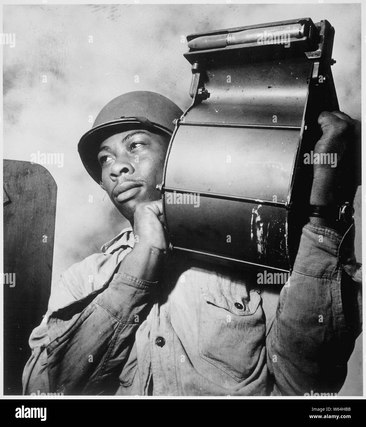 Crewmen aboard U.S.S. Tulagi (CVE-72) en route to southern France for Aug. 15th invasion. Miles Davis King, StM 2/c, carrying a loaded magazine to his 20mm gun., 08/1944 Stock Photo