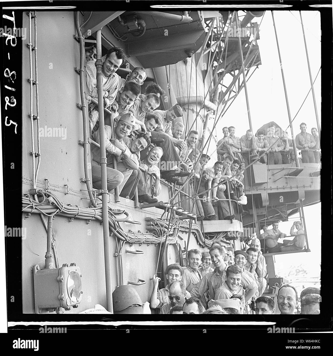 Crewmen laughing as they listen to pilots humorously describe encounter with Jap planes over bullhorn aboard the USS Lexington (CV-16). Stock Photo