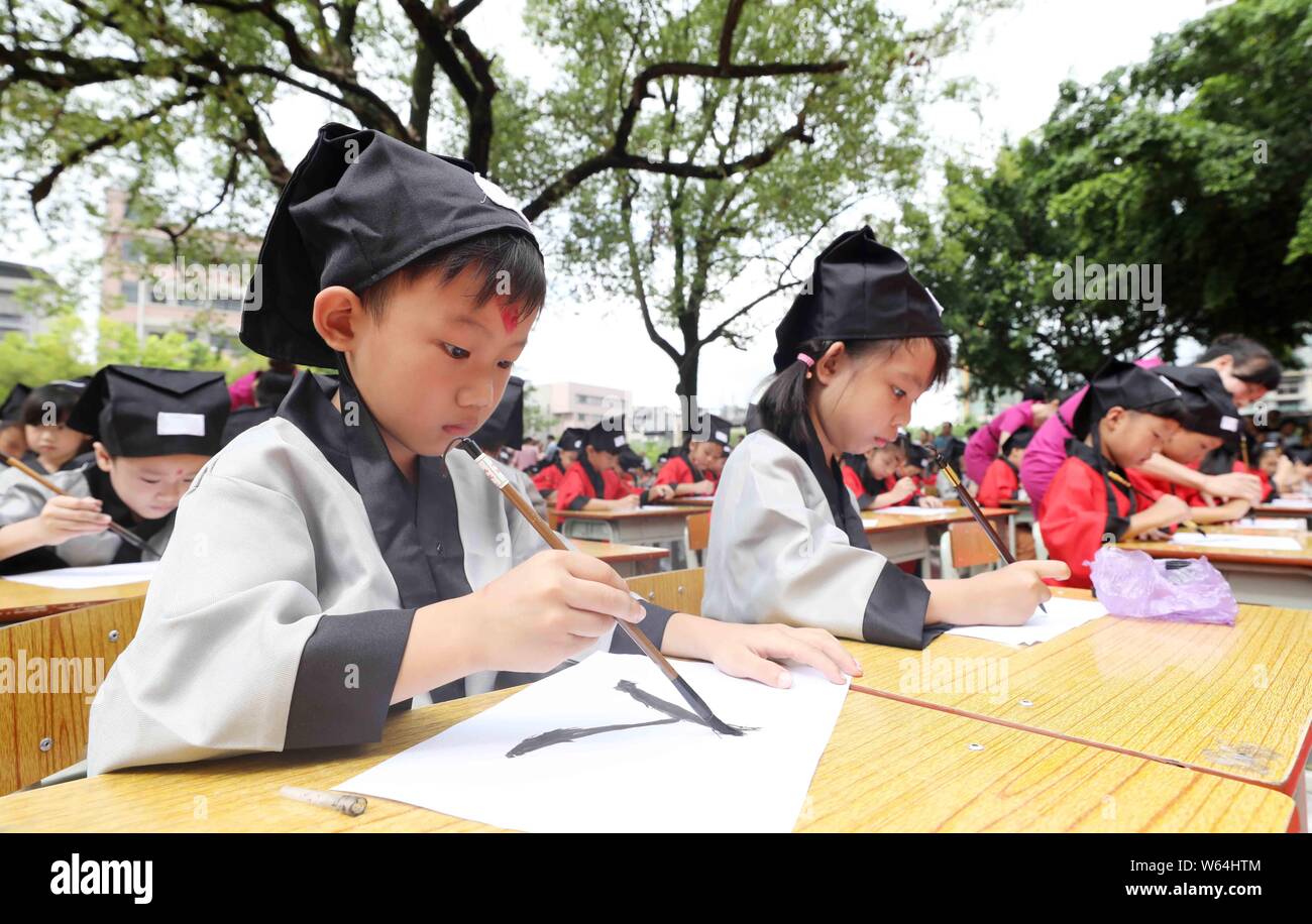 Children write the Chinese character "ren," meaning "human" in English