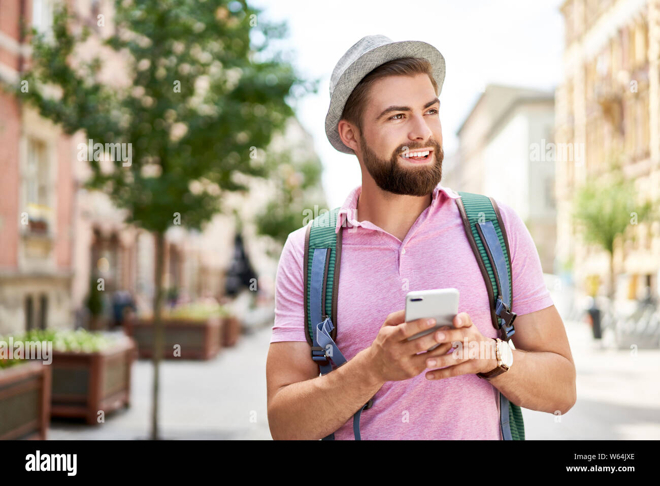 Man with backpack using phone during Europe trip Stock Photo