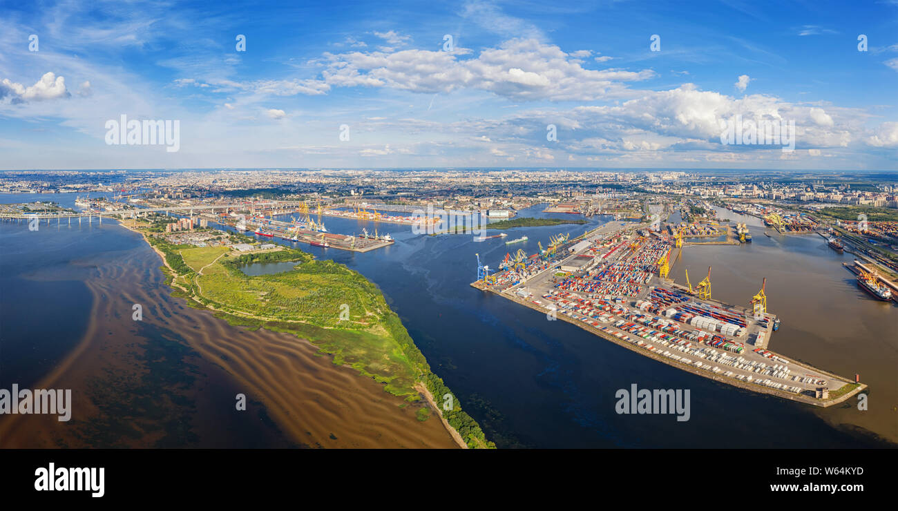 Aerial panoramic view on sea port with cargo containers in Saint Petersburg, Russia against distant city and cloudy sky Stock Photo
