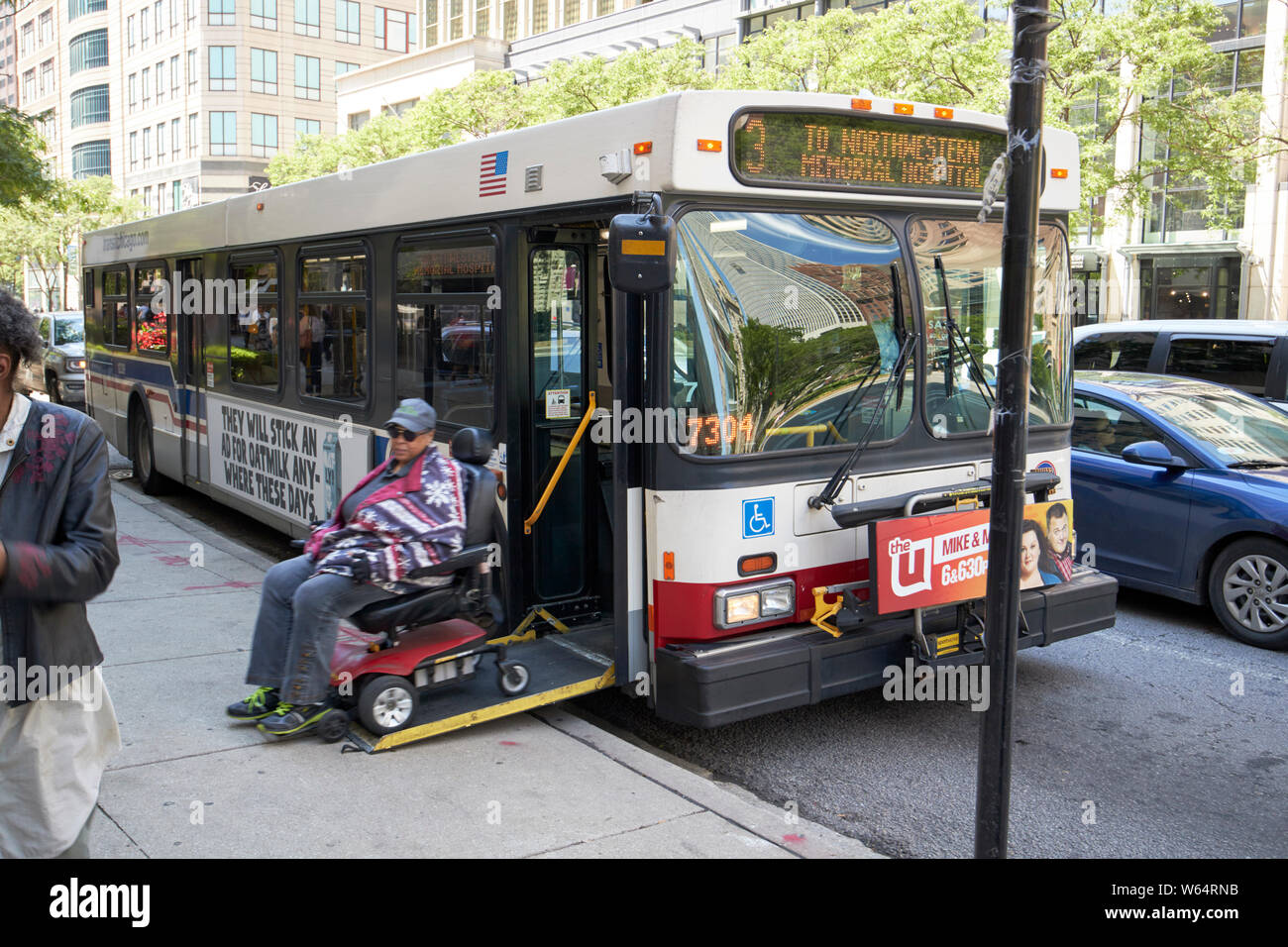 chicago cta accessible bus with woman on motorised wheelchair exiting front door ramp Chicago IL USA Stock Photo